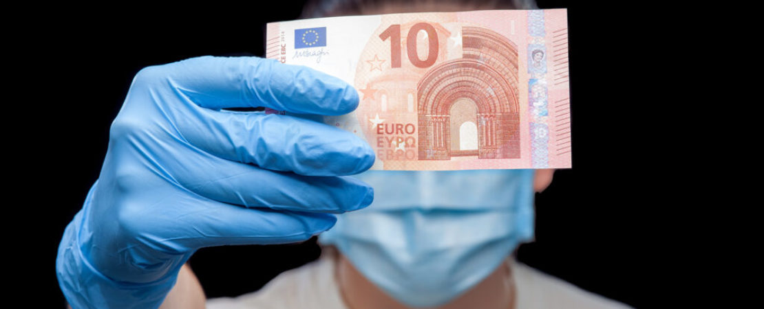 Portrait of a doctor in a medical mask and surgical glove hold a banknote ten Euro, close up of a conceptual background on the topic of corruption in medical medicine.